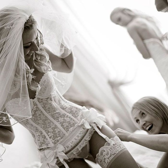 Невеста снимает свадебный наряд в номере отеля готовясь к брачной ночью
